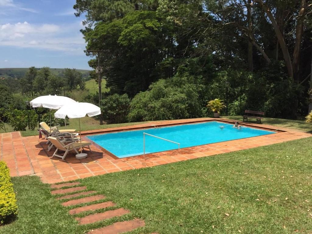 Piscina com deck de pedra e vista para o campo